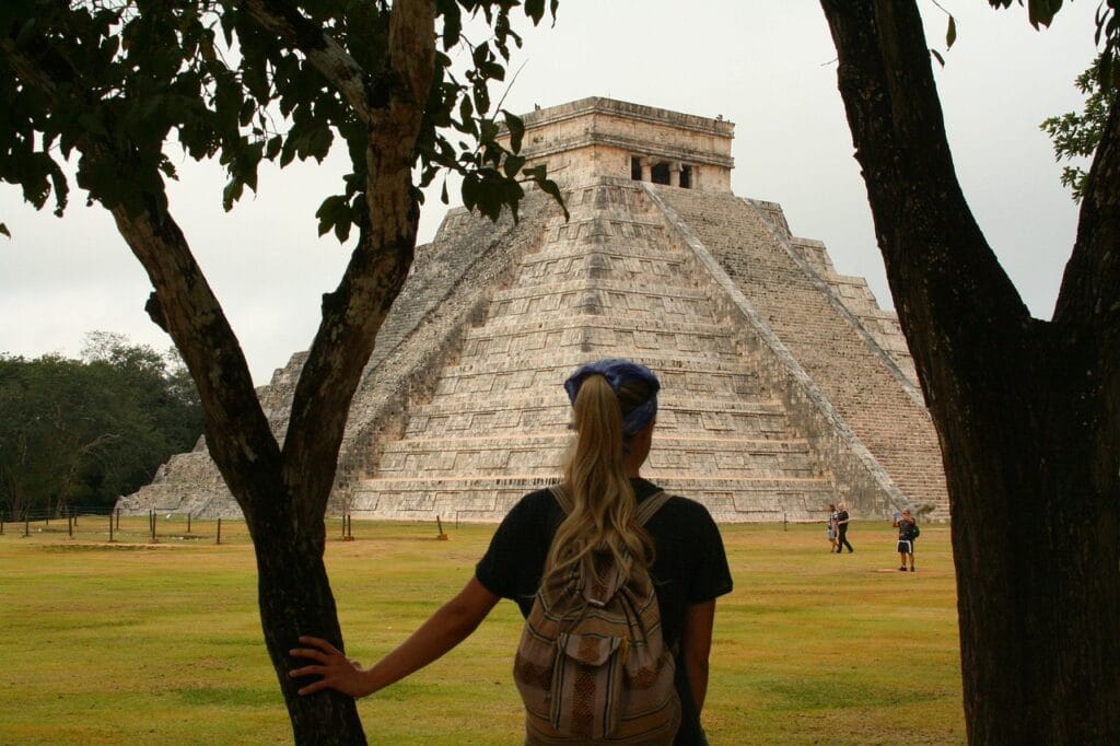 Voyage au Mexique en 2025 - Visiter Chichen Itza - jeune femme contemplant la pyramide de Kukulcan (El Castillo) - Agence de voyage NostaLatina ANN