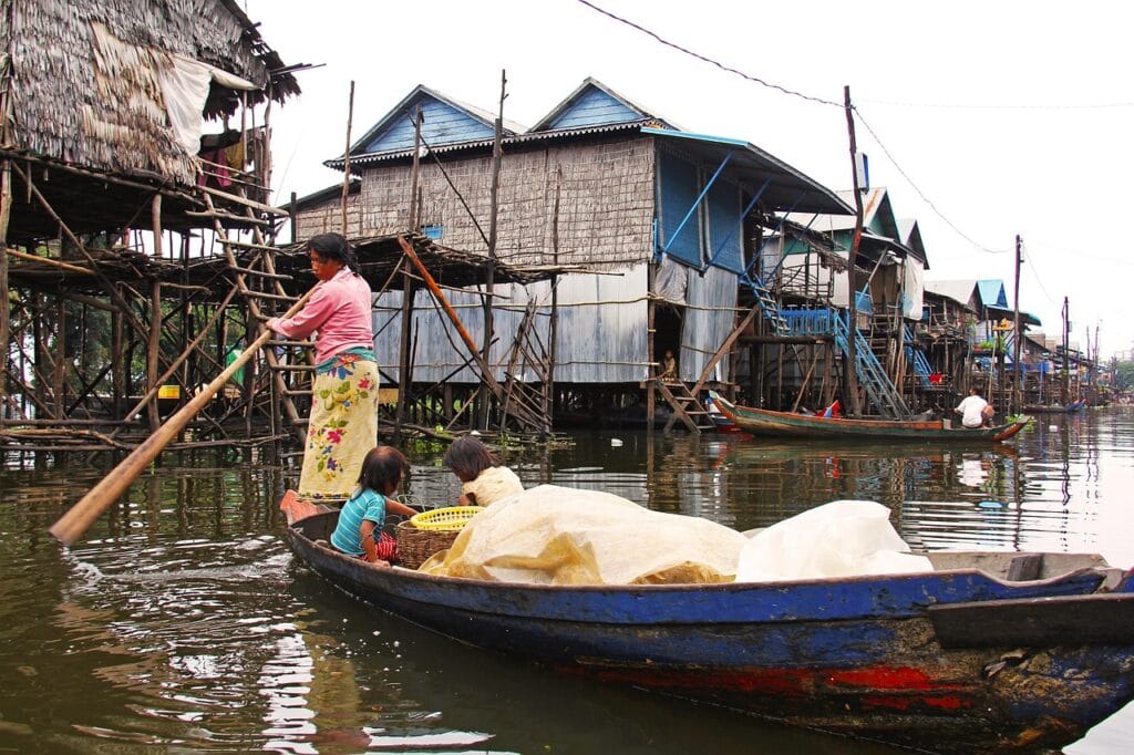 Voyage au Cambodge en 2026 - Femme ramant pour ranger son bateau sur le lac Tonlé Sap - Voyage sur mesure avec NostalAsia ANN